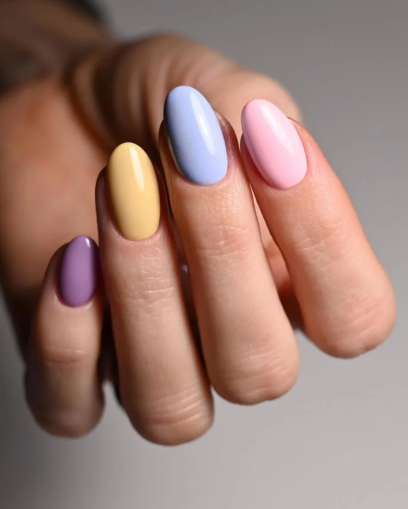 Multi-pastel skittle nails in lavender yellow blue and pink on almond nails August nails color 2026 ideas