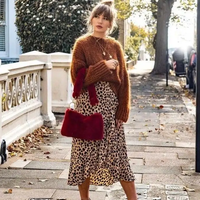Rust chunky sweater with leopard midi skirt and red fur bag