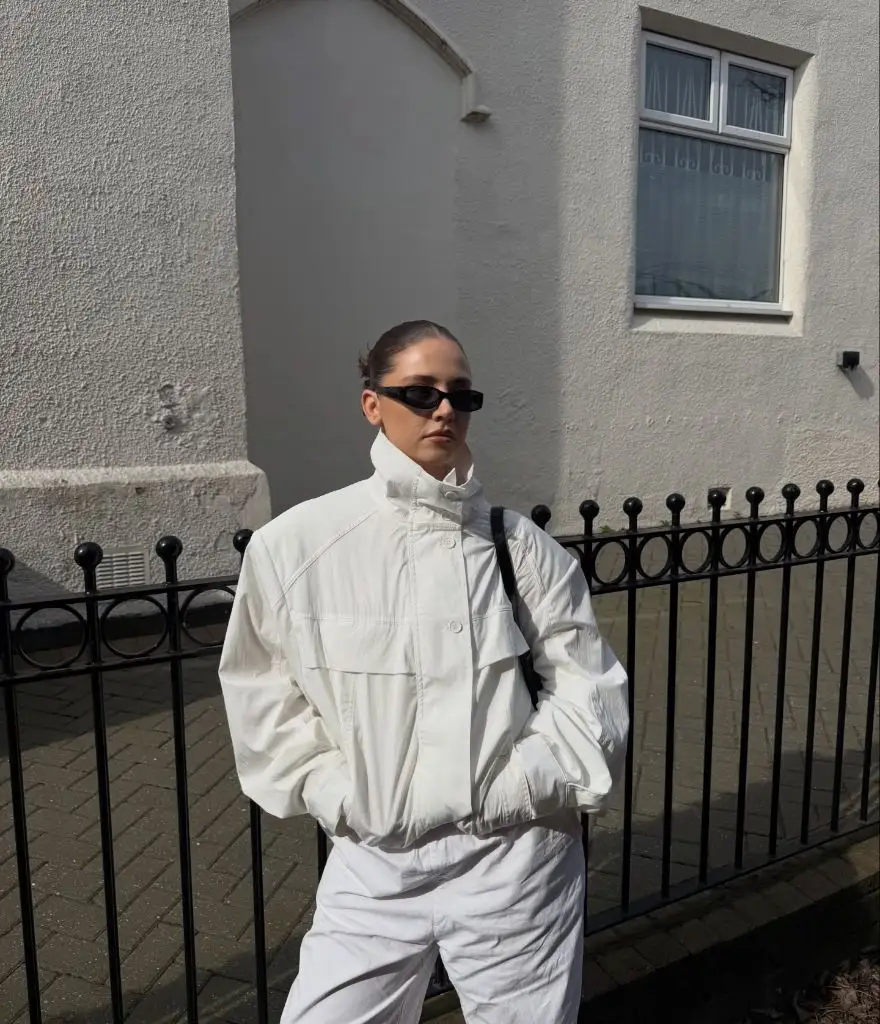 All-white outfit with windbreaker jacket and black sunglasses