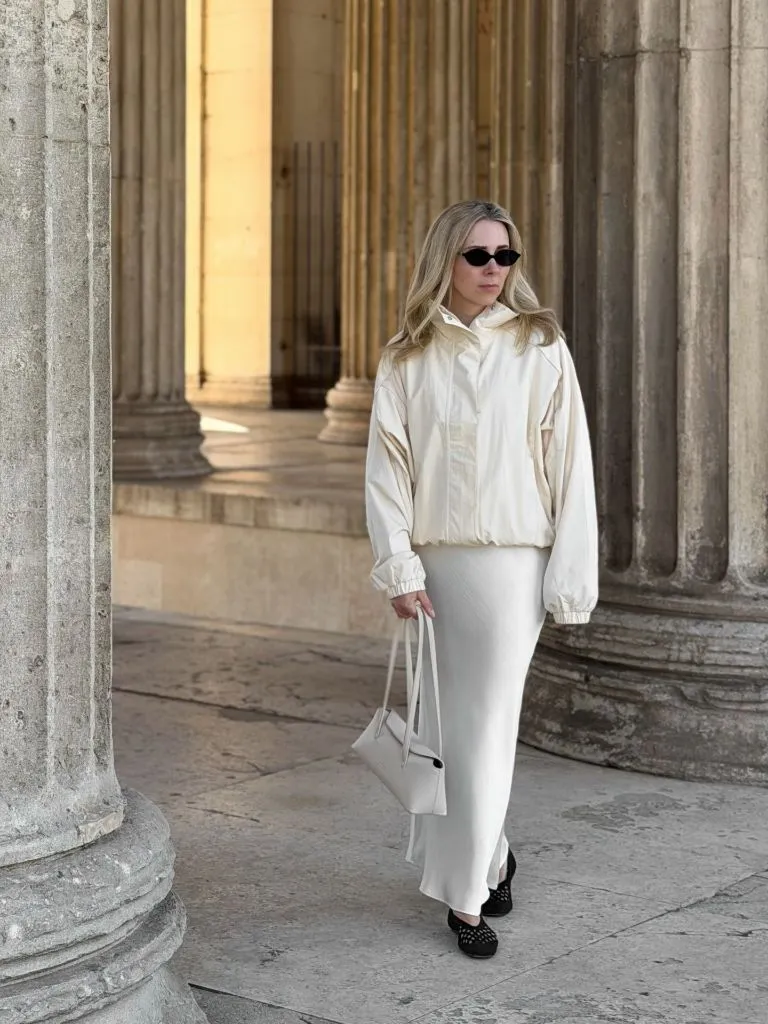 All-ivory outfit with bomber jacket, maxi skirt, and black ballet flats