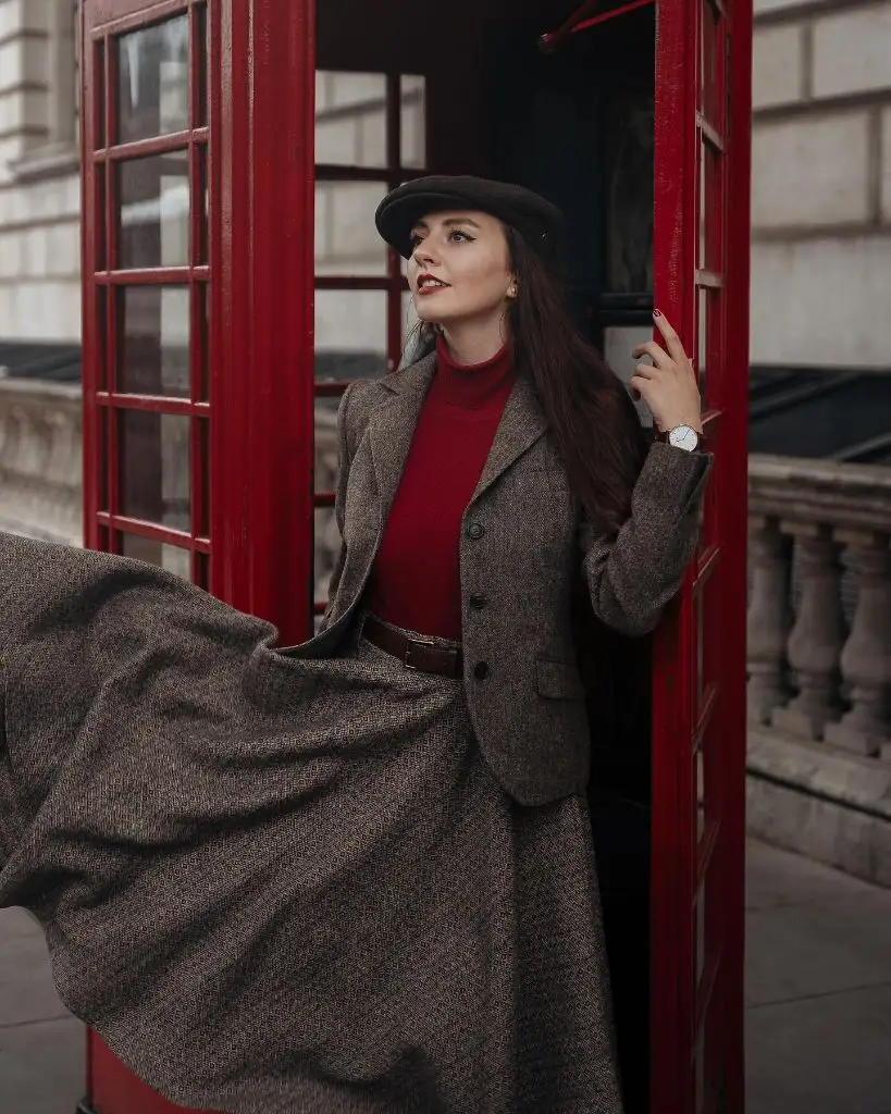 Tweed blazer and flowing skirt with red turtleneck and beret at a London phone box