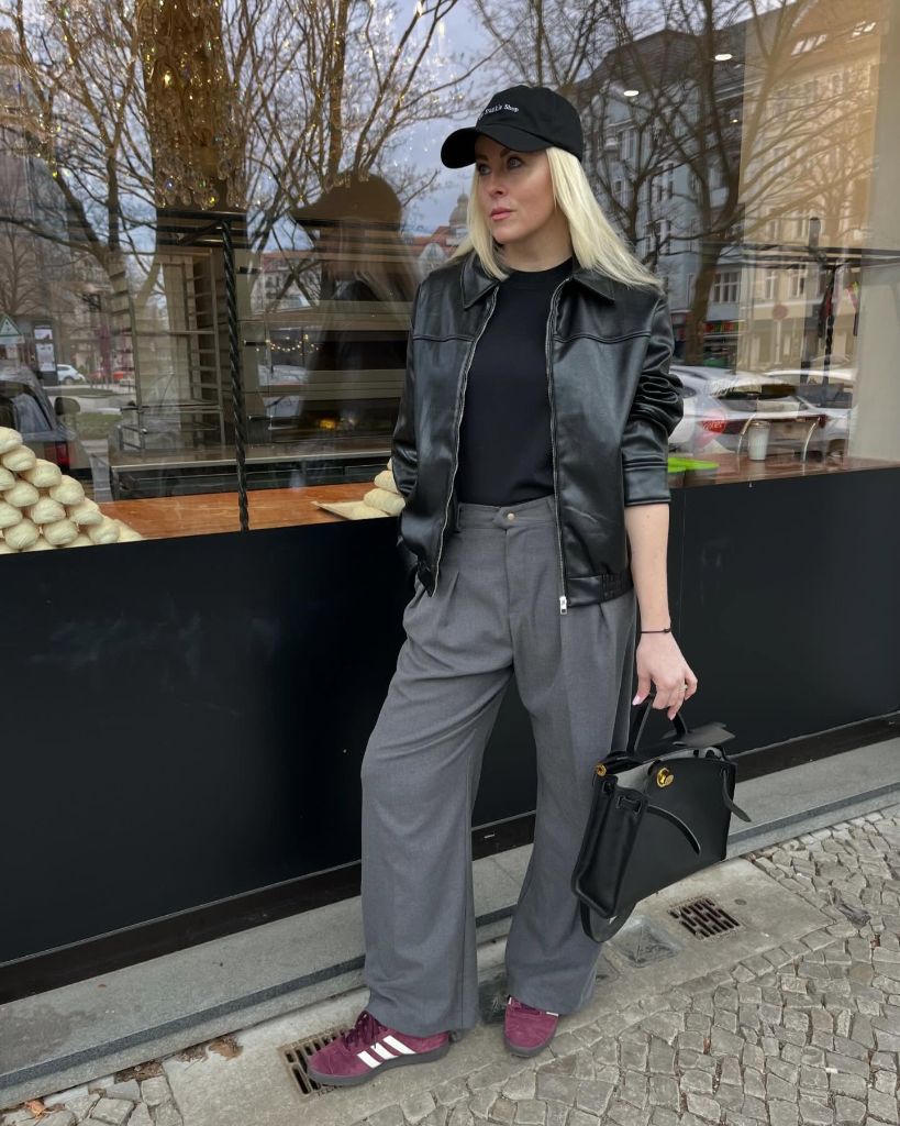 Fall professional outfit black leather jacket grey wide-leg trousers cap burgundy sneakers