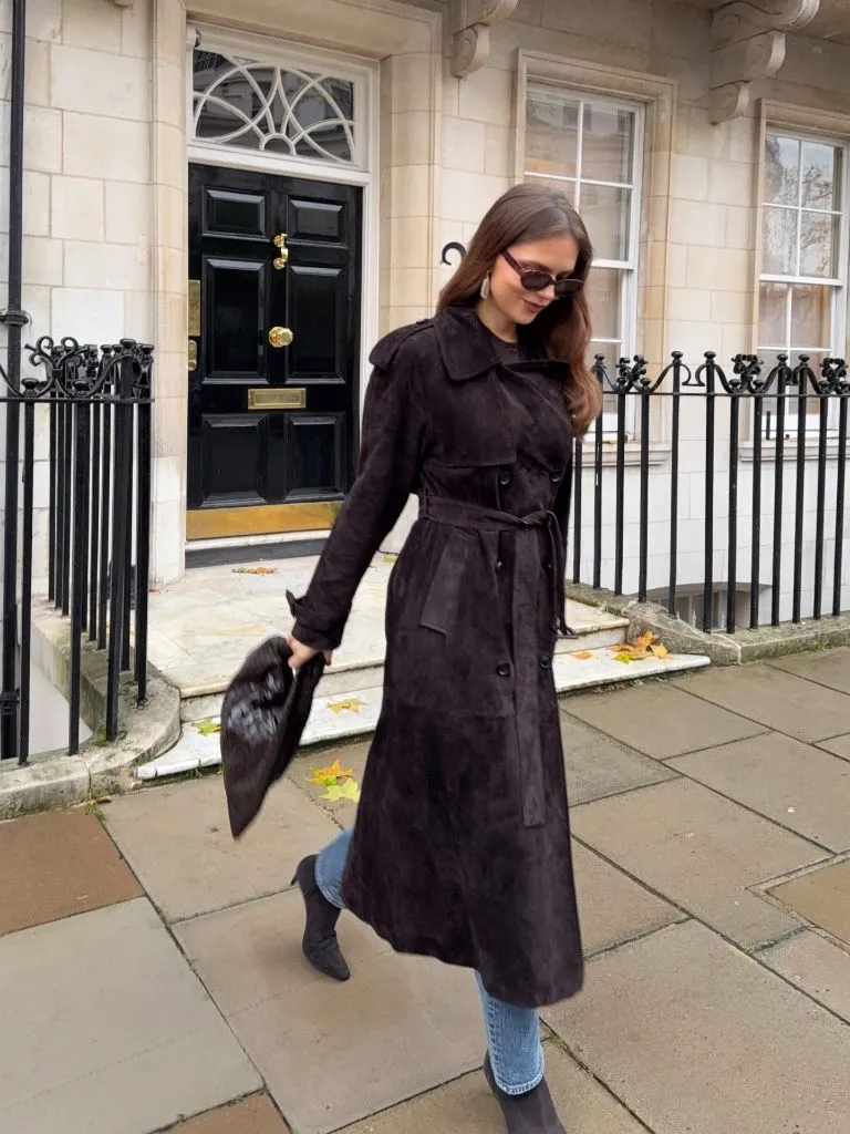 Dark brown suede belted trench coat with light jeans and ankle boots on a London residential street