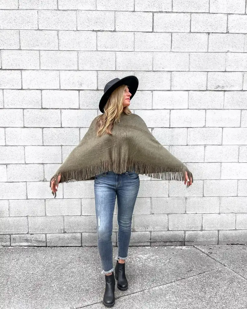 Olive fringed poncho with jeans and black hat