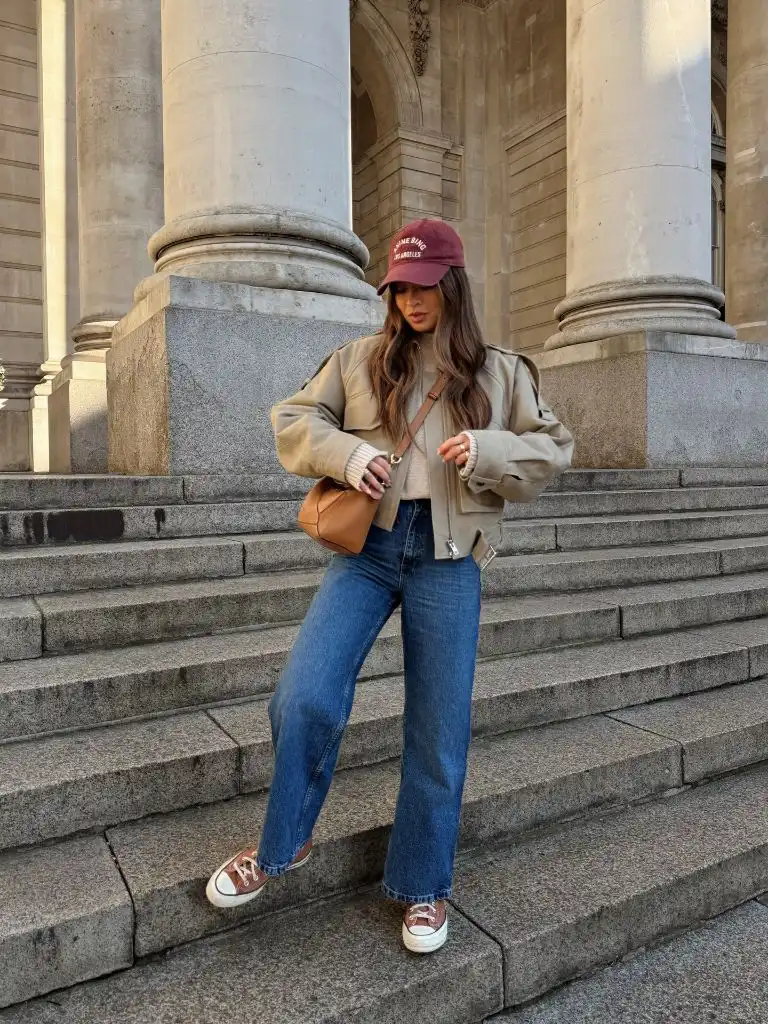Tan bomber style jacket with wide leg jeans and Anine Bing cap