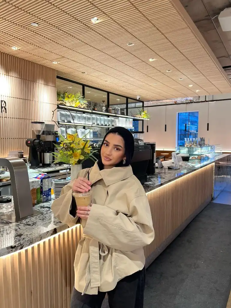 Beige oversized belted peacoat at a modern café