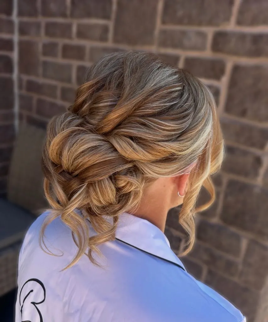 Fall Hairstyles for Wedding Guests 2026 Romantic Tousled Low Updo with Swept Curls