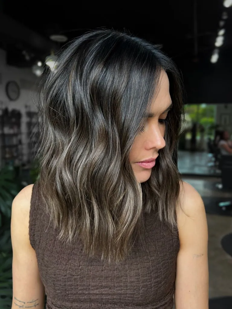 Cool smoky brunette with icy blonde ribbons and beachy waves