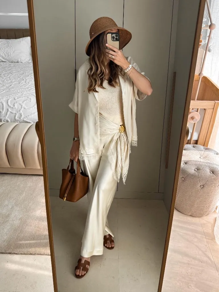 All-cream outfit with satin pants, lace-trim shirt, and brown accessories