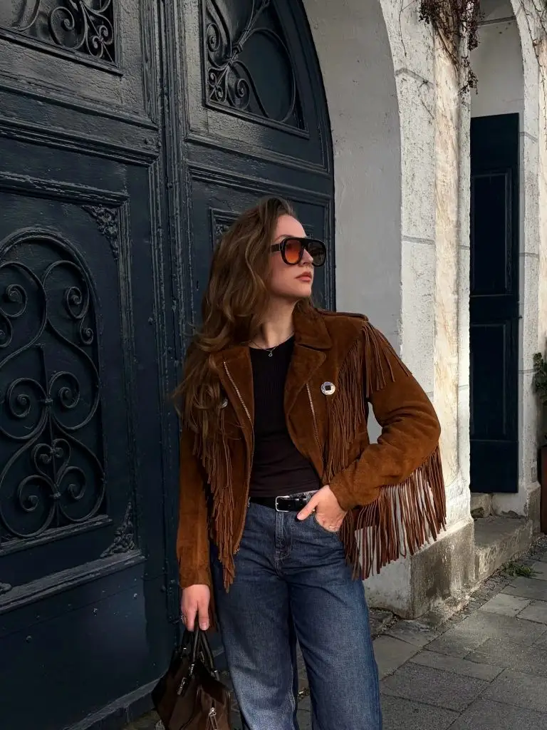 Brown suede fringe jacket with dark jeans and oversized sunglasses