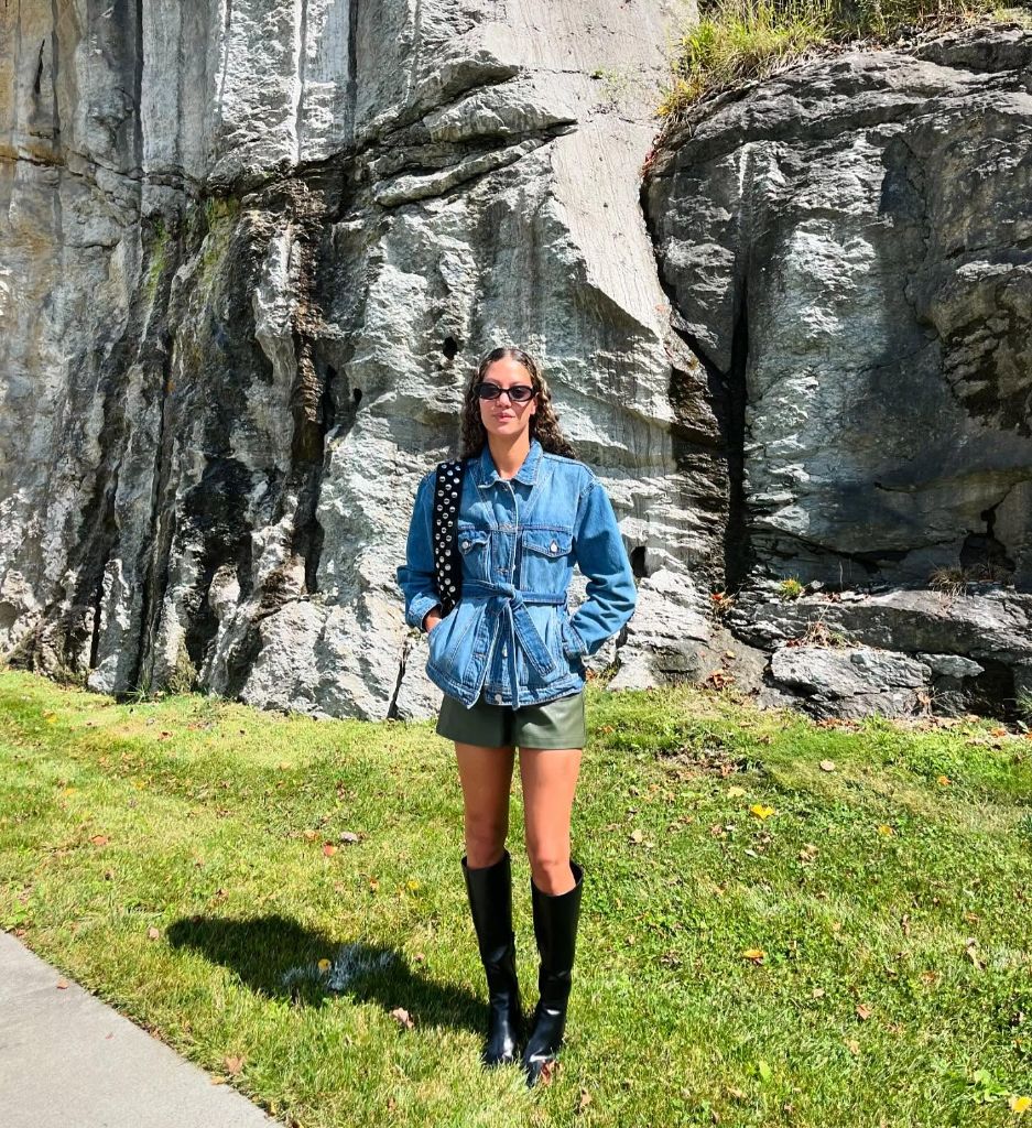 Belted denim jacket with olive green leather shorts and black knee-high boots