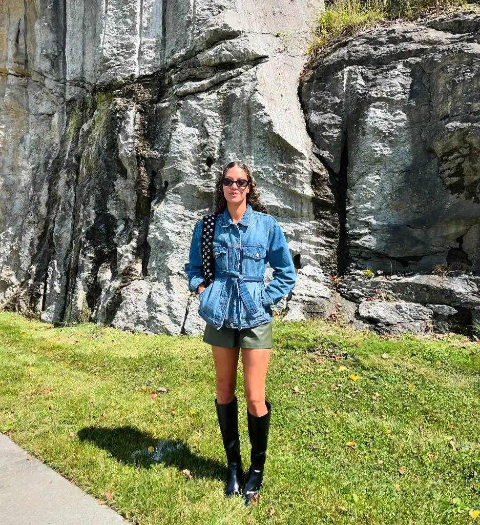 Belted denim jacket with olive green leather shorts and black knee-high boots