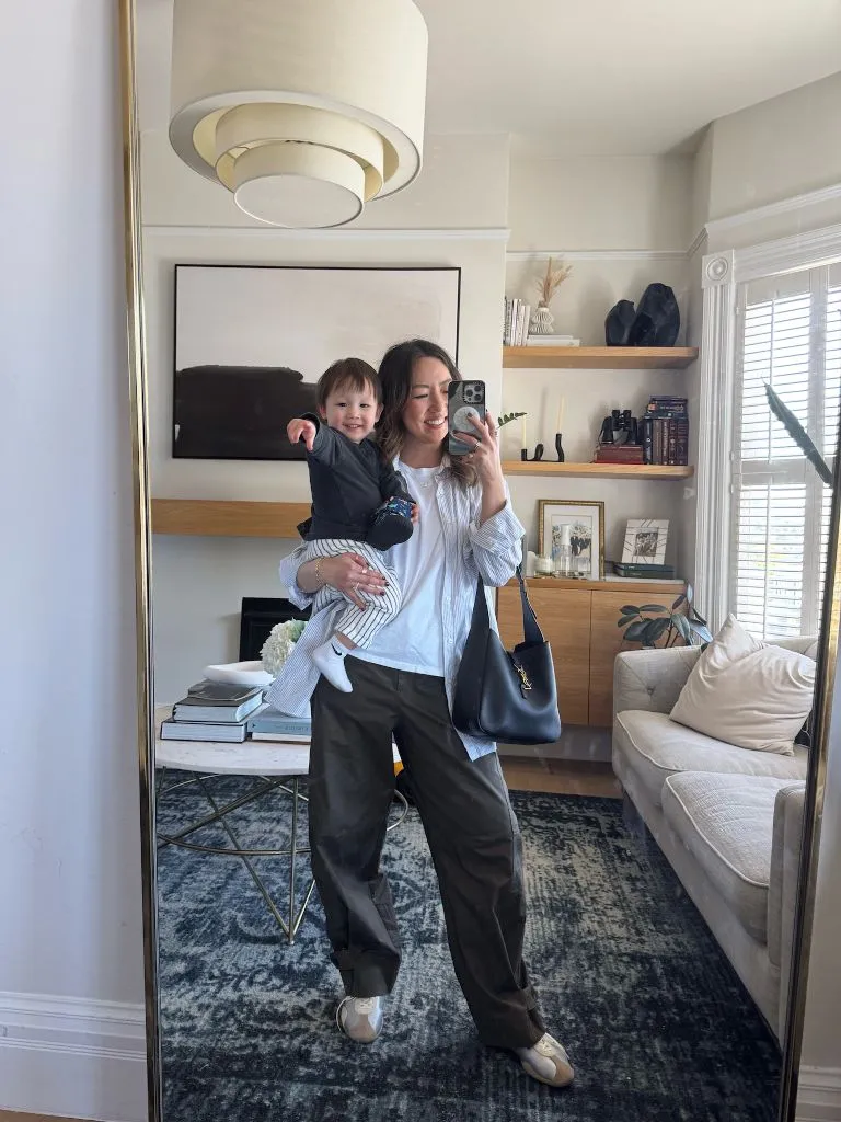 Mirror selfie with child in button-down shirt and olive trousers