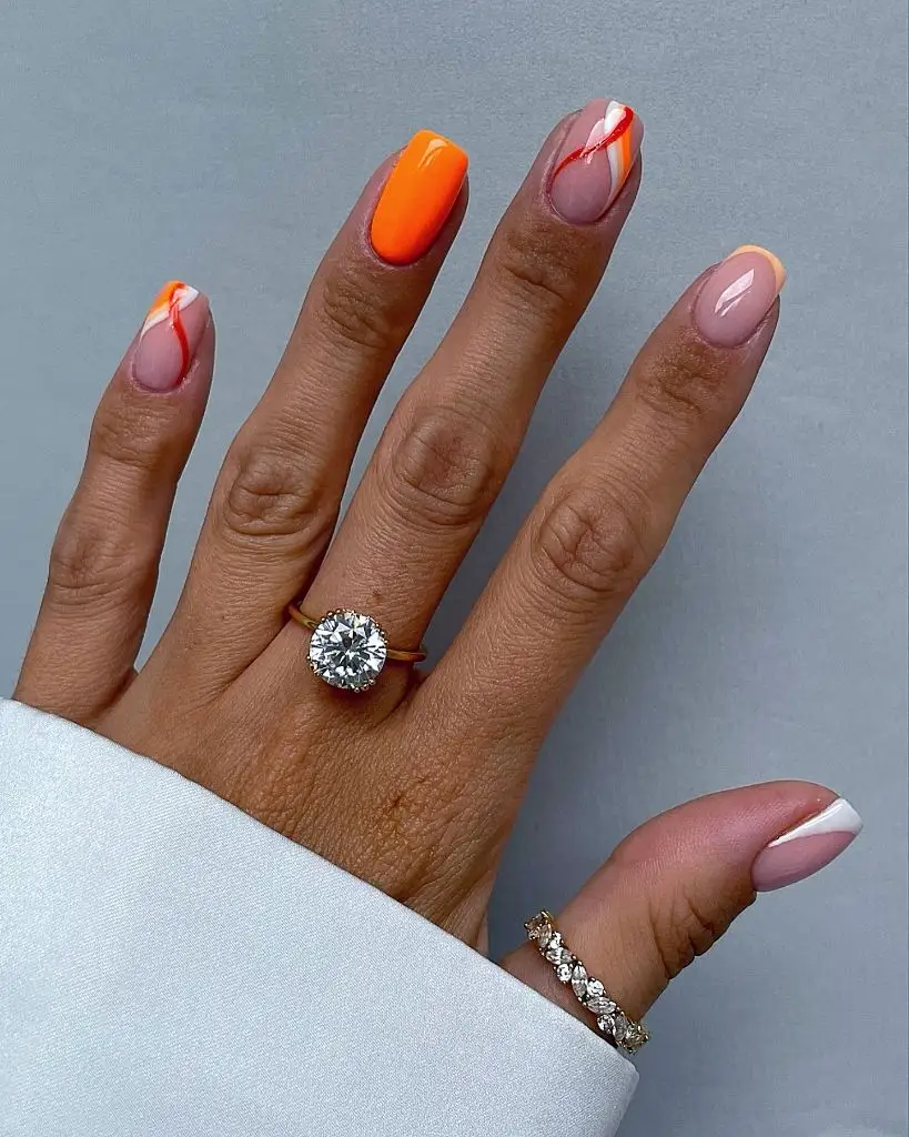 Bright tangerine orange nails with abstract swirl art and French tips, August nails 2026