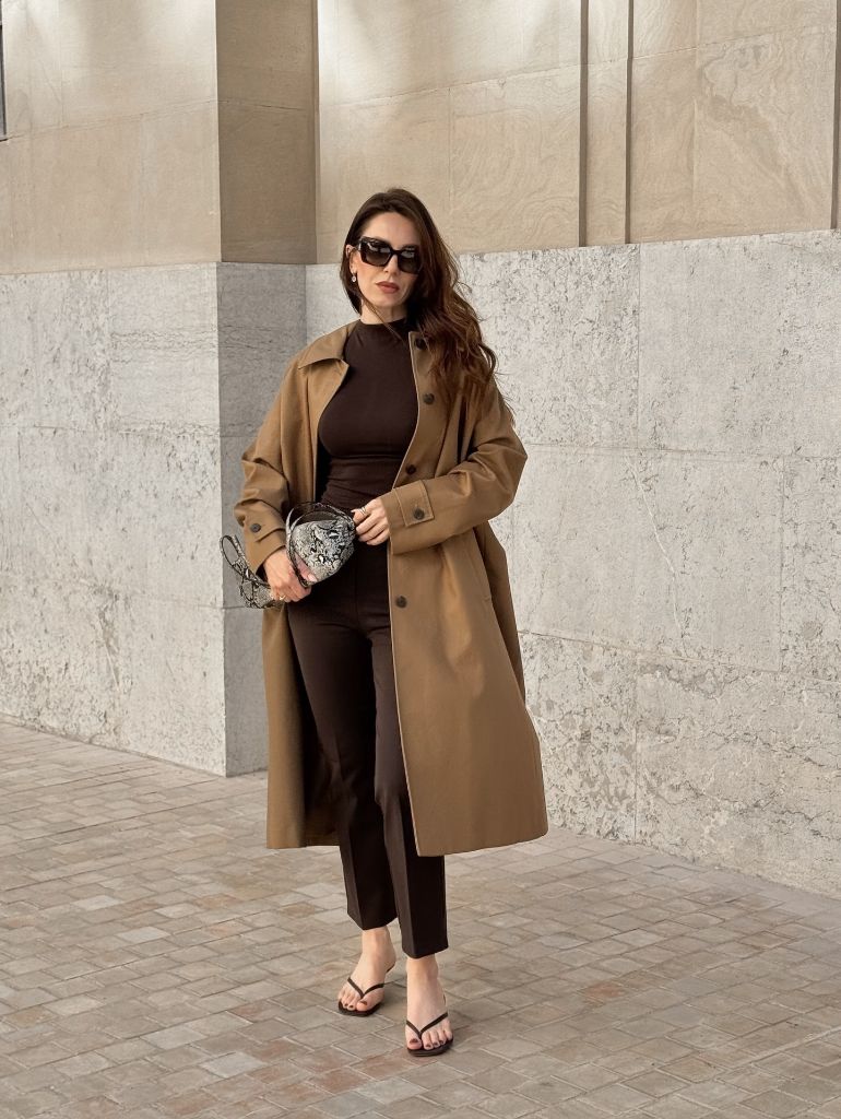 Camel trench coat over chocolate brown outfit with snakeskin bag
