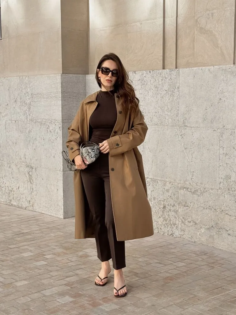 Camel trench coat over chocolate brown outfit with snakeskin bag