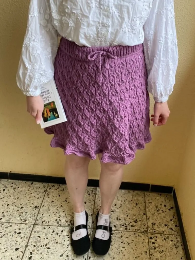 Purple lace-knit mini skirt with ruffled hem and white blouse