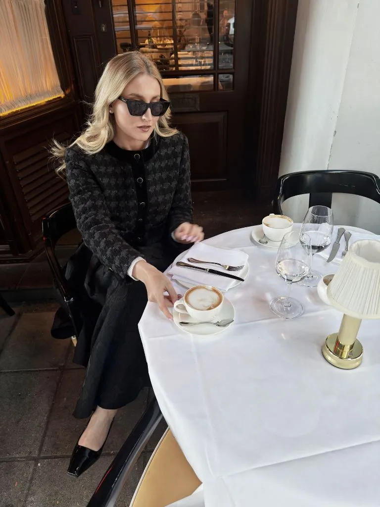 Black houndstooth jacket outfit at European café with espresso