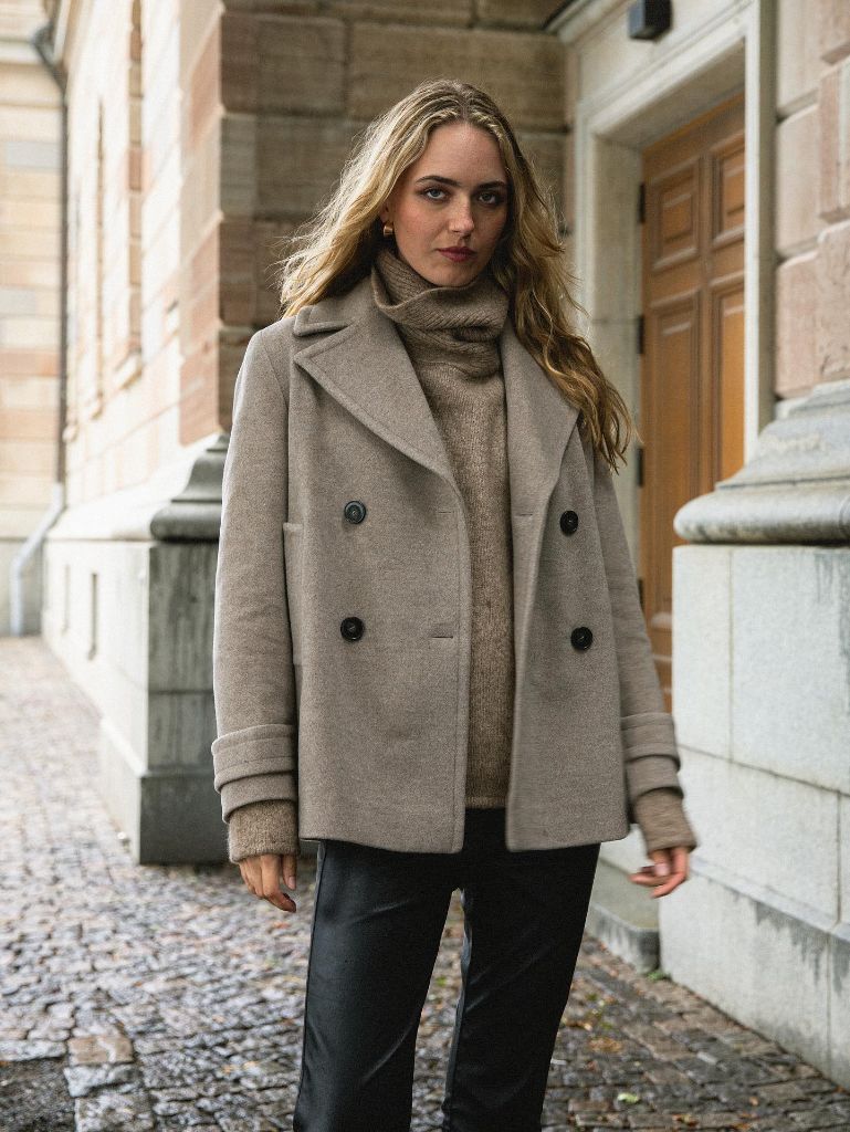 Grey wool peacoat over taupe turtleneck with black leather pants