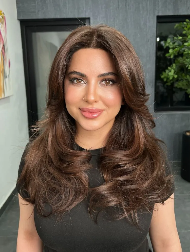 Rich chocolate brown voluminous blowout with face-framing layers