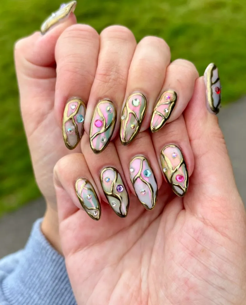 Stained glass nail design with gold outlines and colorful gems, August nails inspiration 2026