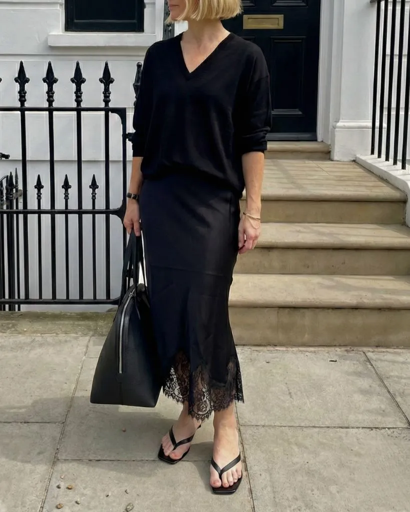 All-black outfit with lace-trimmed slip skirt and thong sandals
