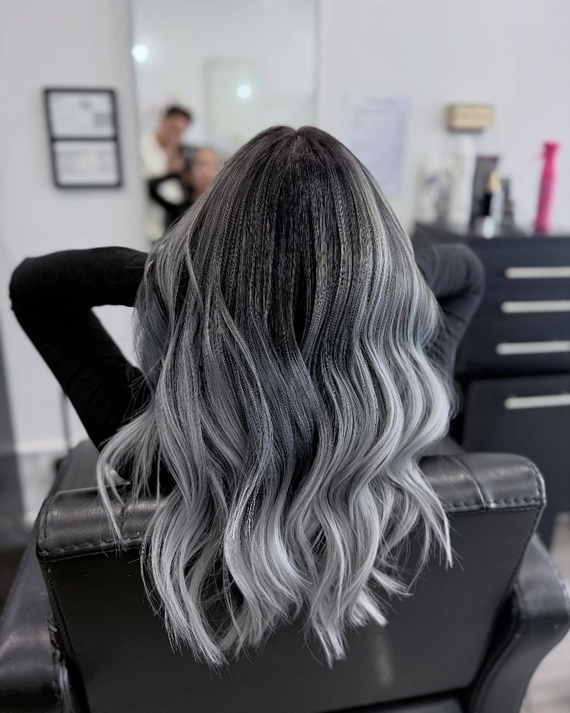 Dark root melting into silver gray waves from the back