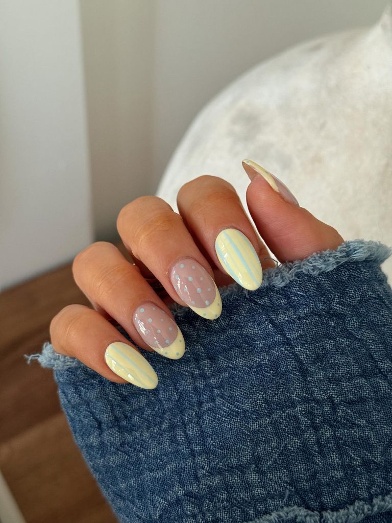 Pastel yellow and baby blue polka dot and stripe nails on almond nails August nails color 2026 ideas