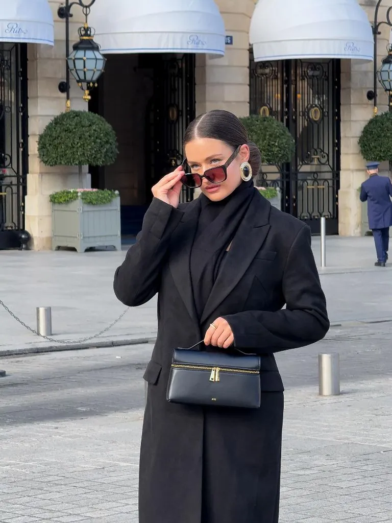 All-black blazer and scarf outfit with structured handbag at the Ritz Paris