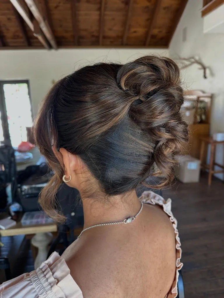 Fall Hairstyles for Wedding Guests 2026 Textured High Bun with Loose Tendrils