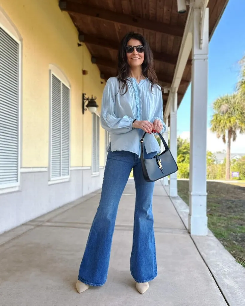 Light blue pintuck blouse with flared jeans and YSL bag