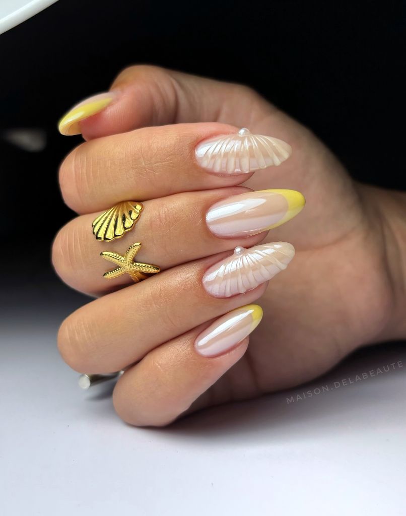 Pearlescent seashell nail art with yellow French tips, a gorgeous August nails idea for 2026
