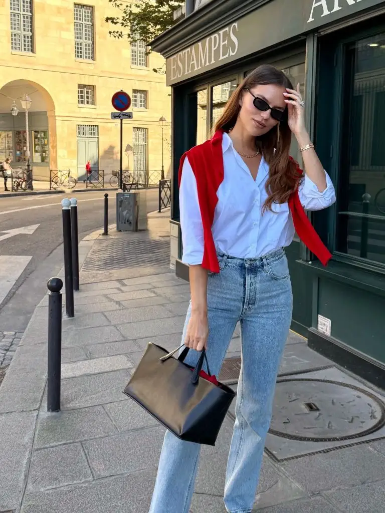 Fall professional outfit white button-down light jeans red sweater draped black bag