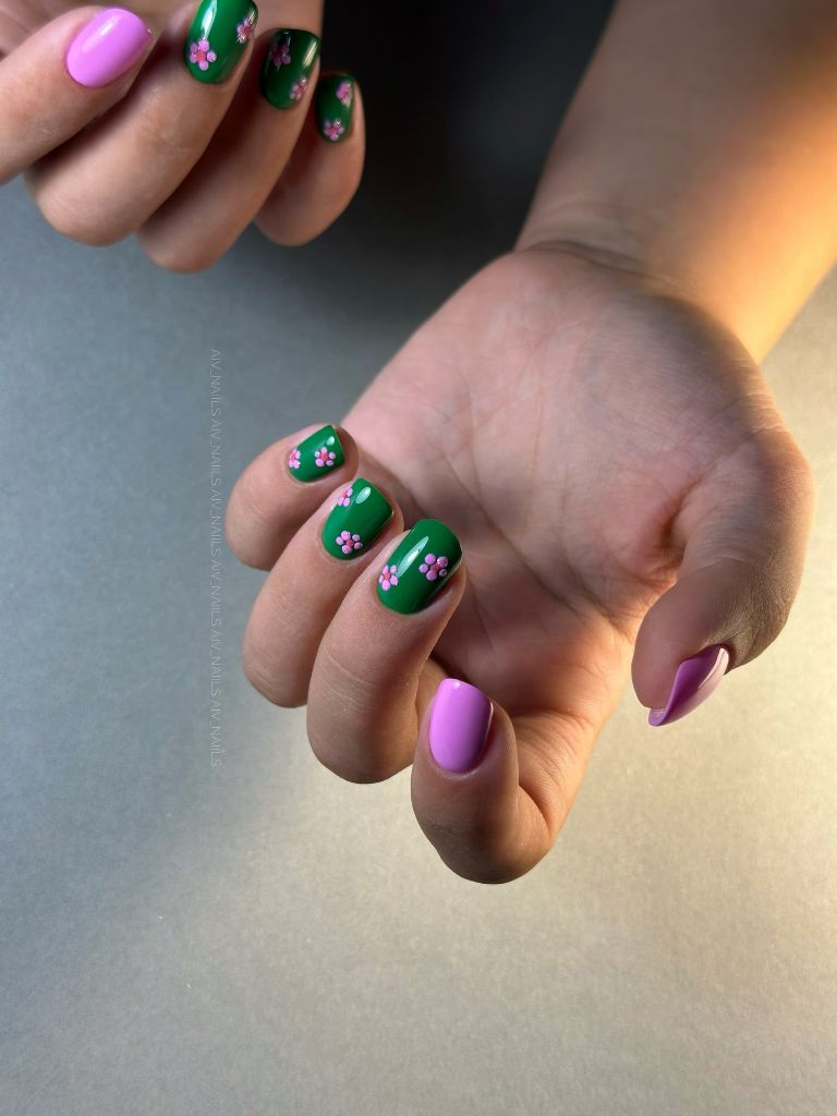 Emerald green nails with pink flower details and lilac accents, cute August nails 2026