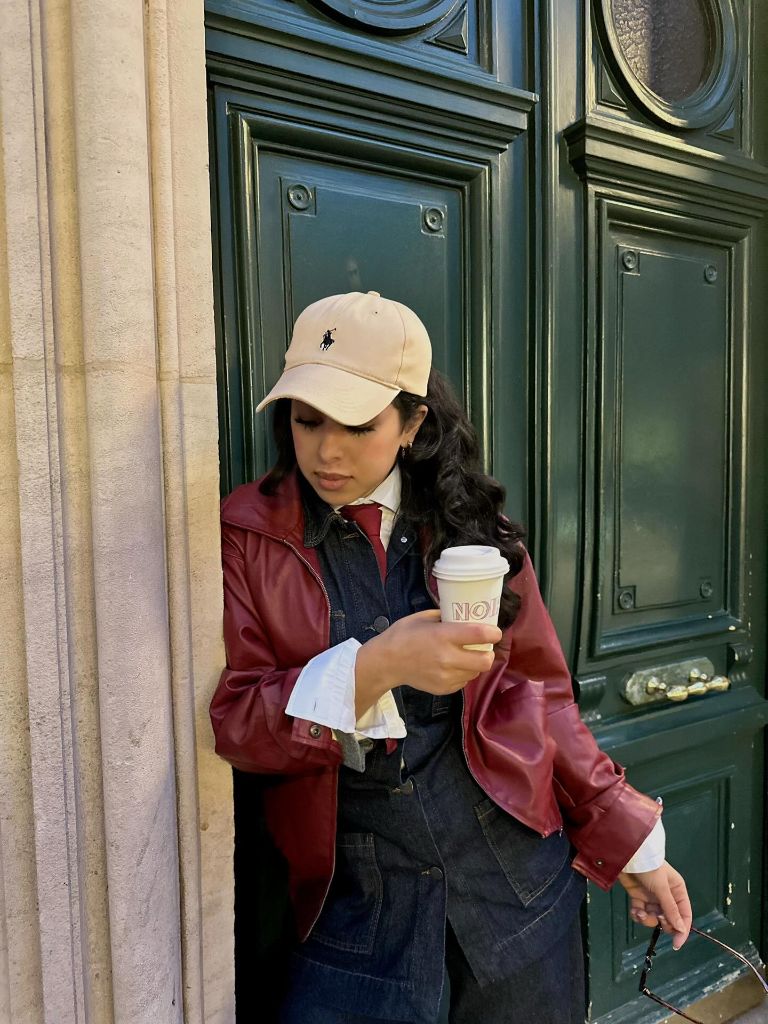Burgundy leather jacket with denim jumpsuit and Ralph Lauren cap