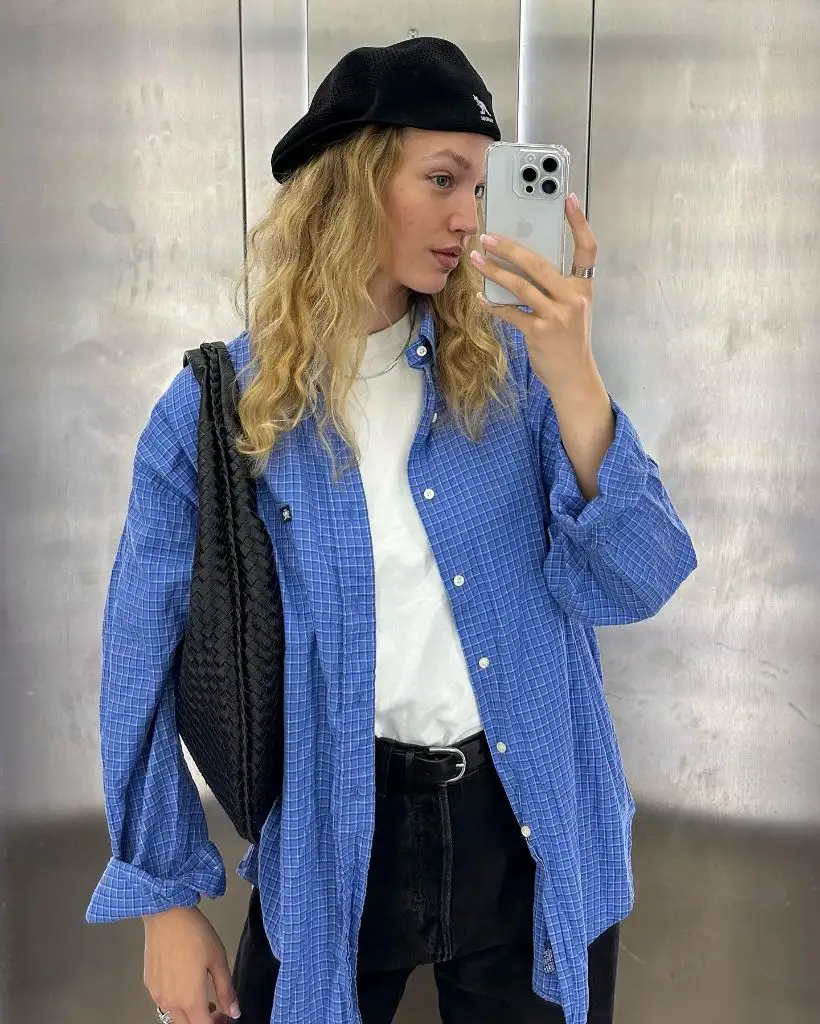 Blue windowpane check oversized shirt over white tee with black jeans, black Kangol beret, and woven black bag