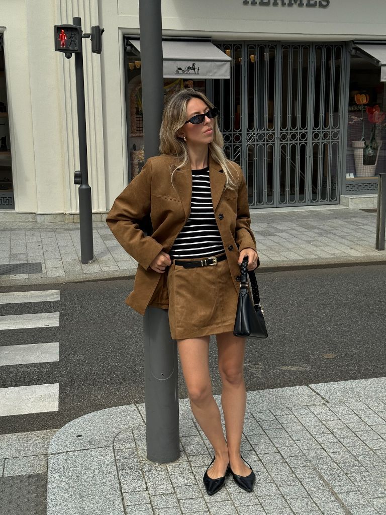 Fall travel outfit featuring brown suede blazer and matching mini skirt with Breton stripe top