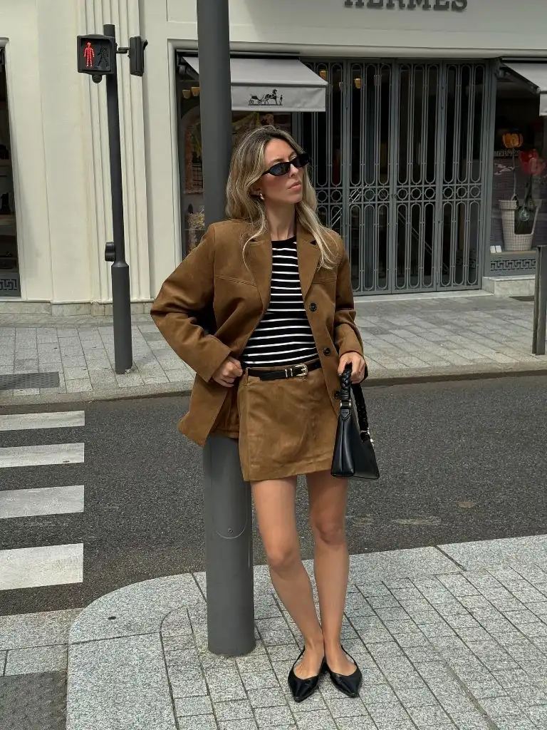 Fall travel outfit featuring brown suede blazer and matching mini skirt with Breton stripe top