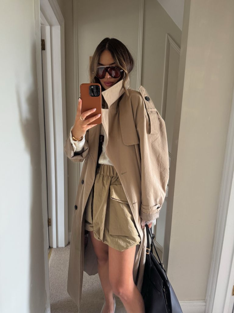 Beige peacoat layered over cream turtleneck with olive cargo shorts