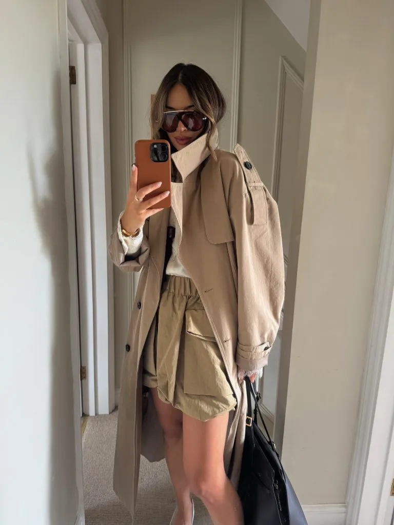 Beige peacoat layered over cream turtleneck with olive cargo shorts