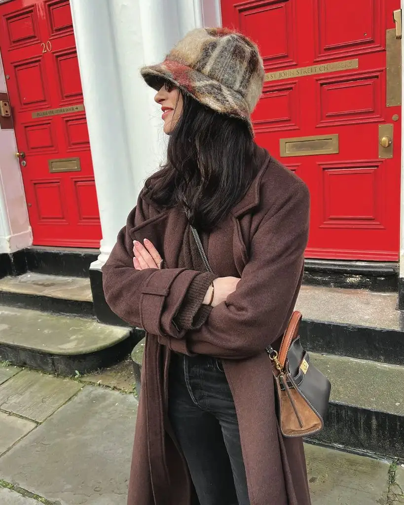 Brown wool coat with plaid bucket hat and crossbody bag on London street