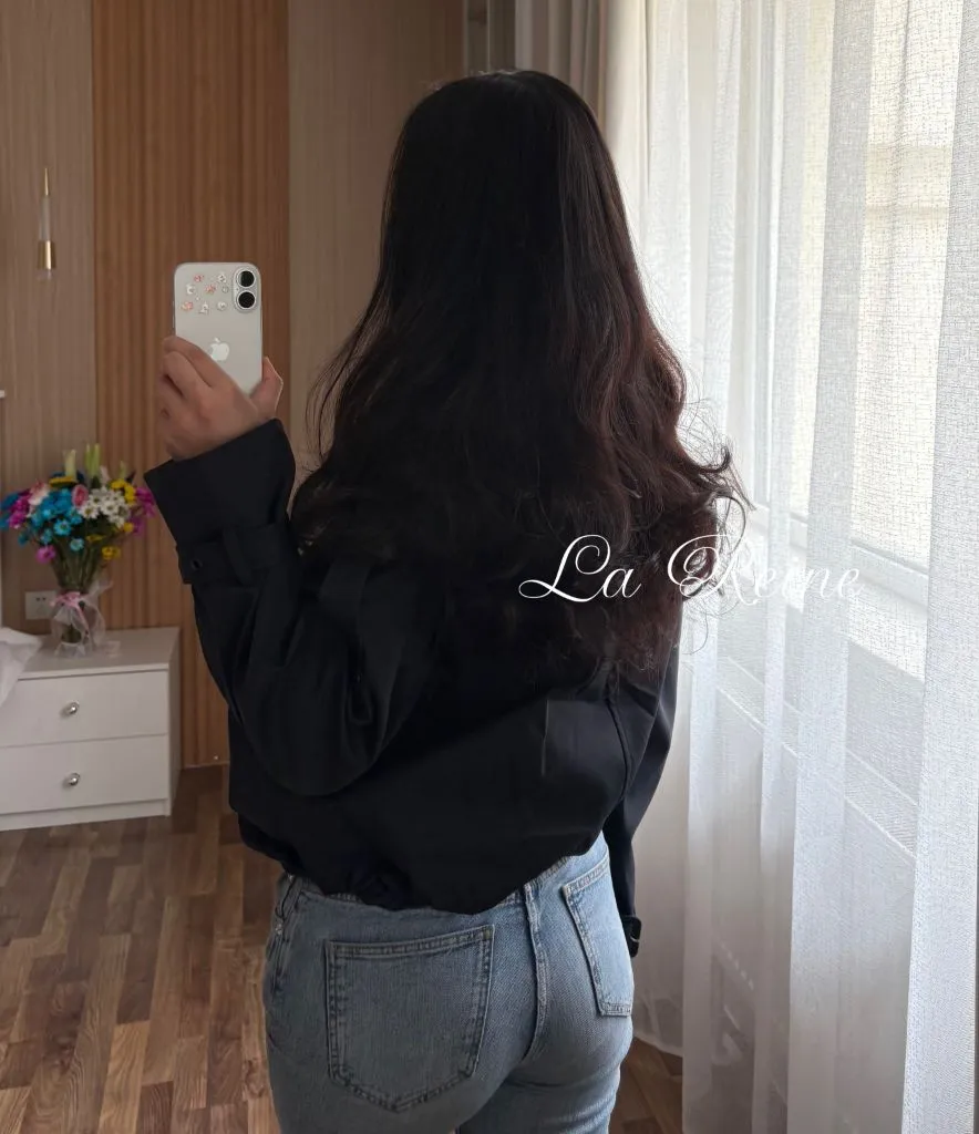 Black cropped jacket shown from behind with light wash jeans