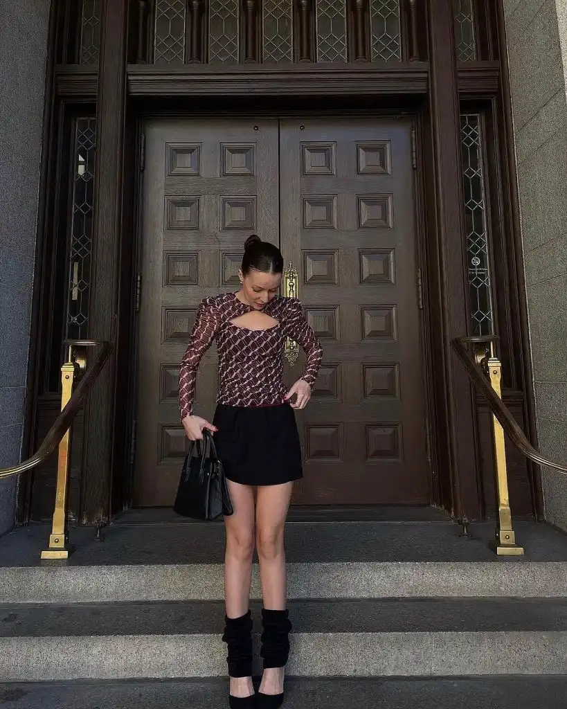 Geometric printed blouse with cutout detail and black mini skirt, velvet leg warmers and heels