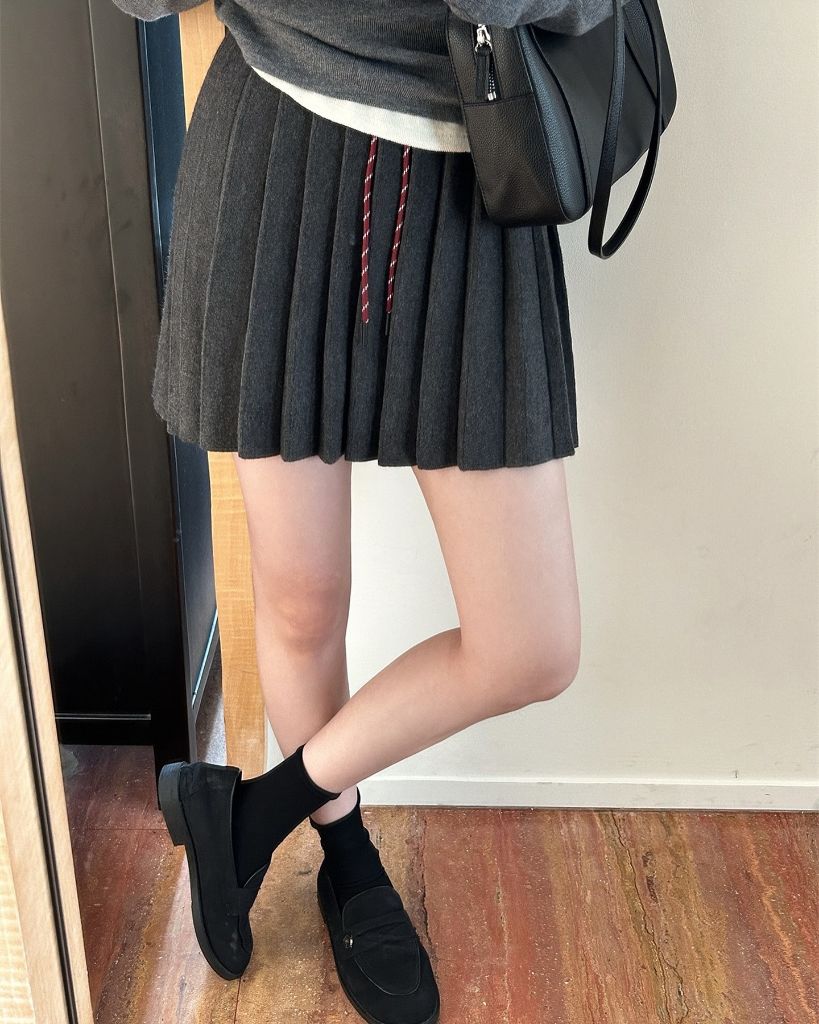 Dark grey pleated knit mini skirt with grey sweater and loafers