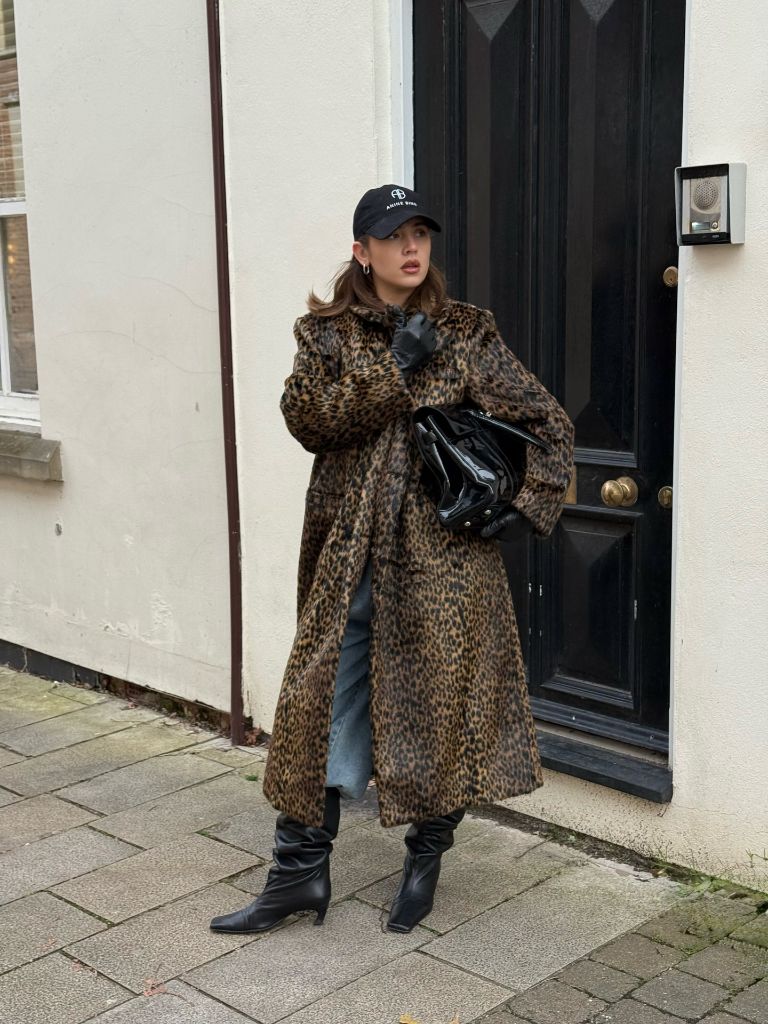 Leopard print coat with jeans, boots, and black cap