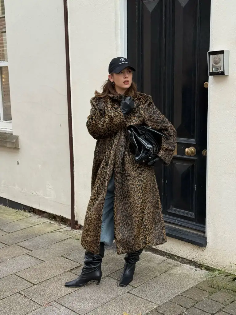 Leopard print coat with jeans, boots, and black cap