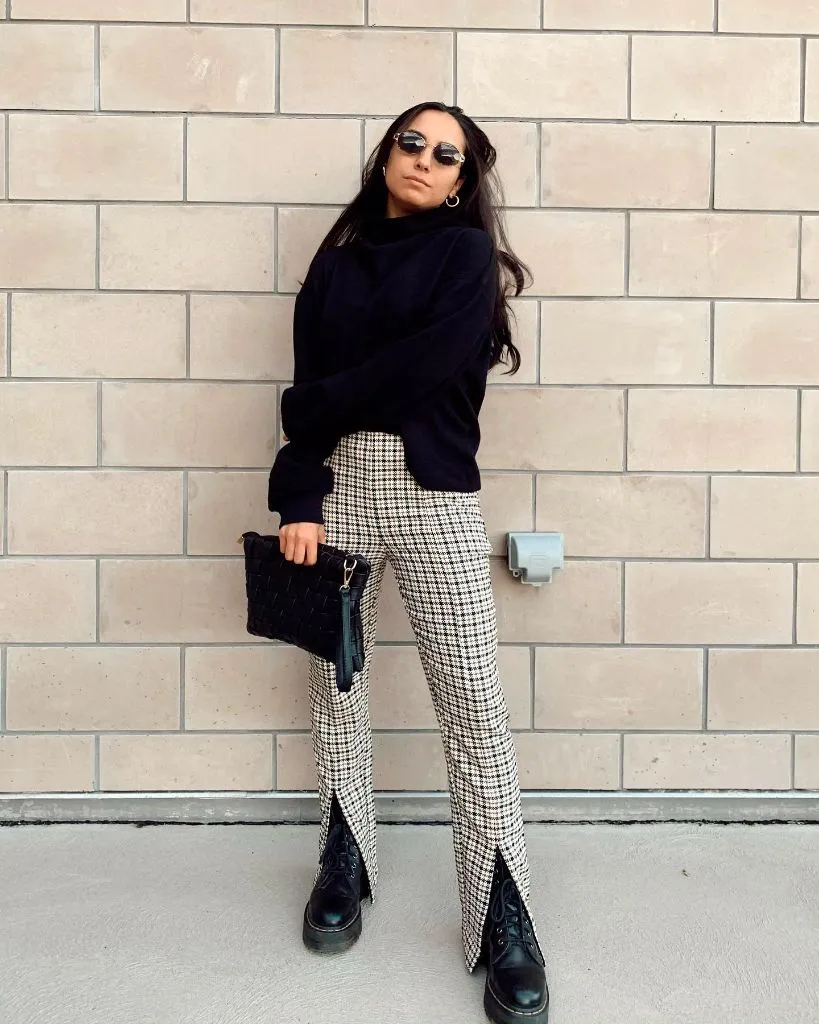 Black turtleneck sweater with houndstooth split-hem trousers and combat boots