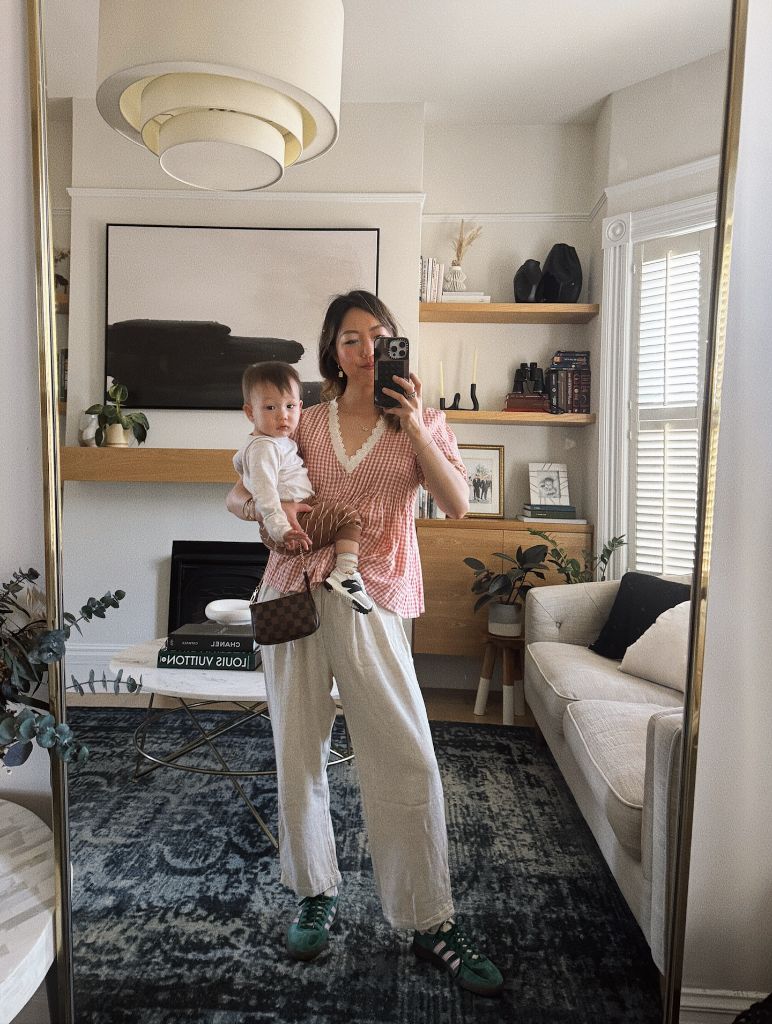 Mirror selfie with baby in pink gingham top and white linen pants
