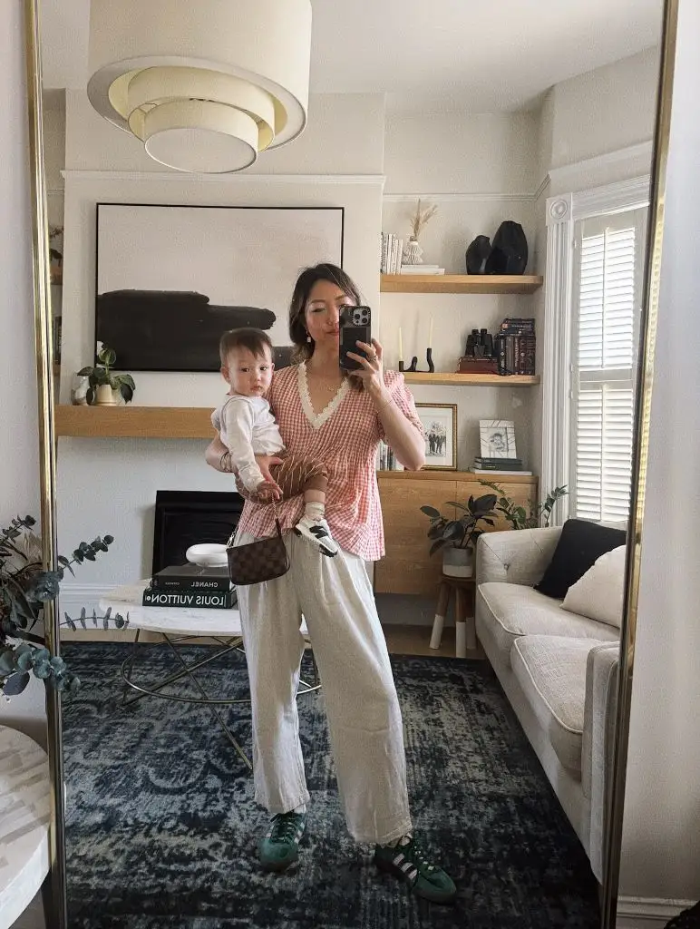 Mirror selfie with baby in pink gingham top and white linen pants