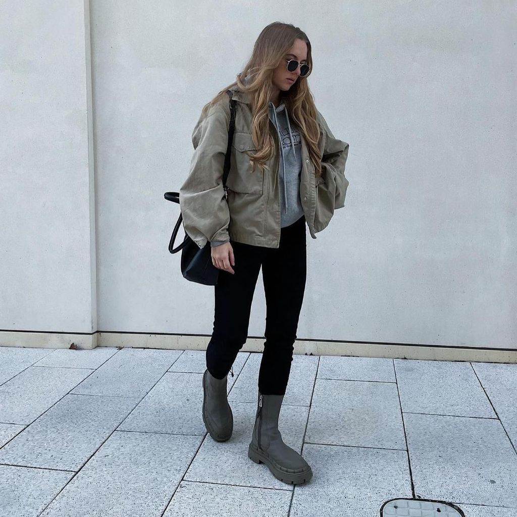 Olive green utility jacket over grey hoodie with black skinny pants and grey chunky boots